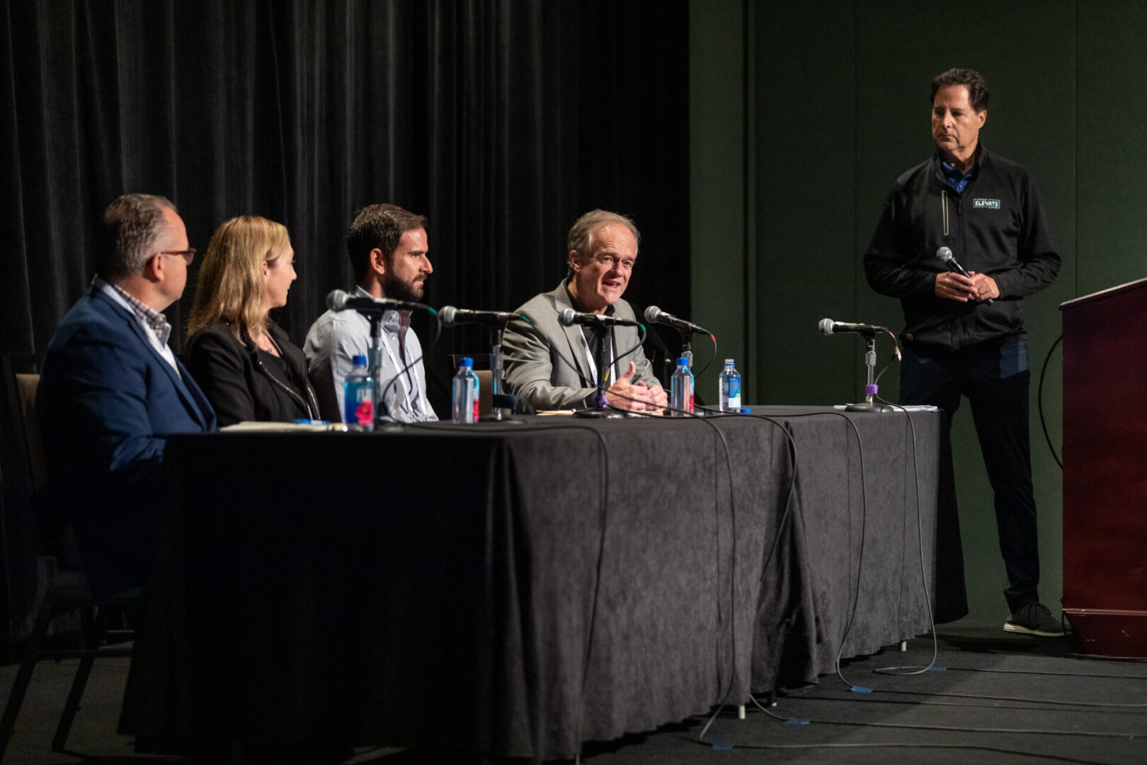David Gee moderating a panel discussion at a conference in Orlando